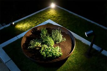 Éclairage ciblé d’un parterre d’herbes aromatiques avec des spots encastrés pour une mise en scène harmonieuse au jardin.
