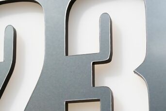 Plaque en aluminium brossé avec découpe précise des chiffres, assurant une finition haut de gamme et une excellente lisibilité.