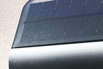 Panneau solaire intégré sur une lampe de numéro de maison, captant l'énergie du soleil pour une illumination autonome et écologique.