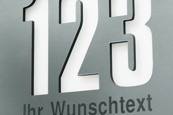 Gros plan sur une plaque de numéro de maison avec découpe rétroéclairée, affichant un numéro personnalisable et un texte au choix.